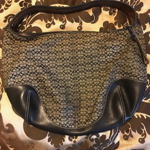 This is a coach hobos hand bag black and gold in color